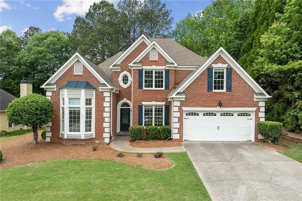 View of front of home featuring brick siding, a ga