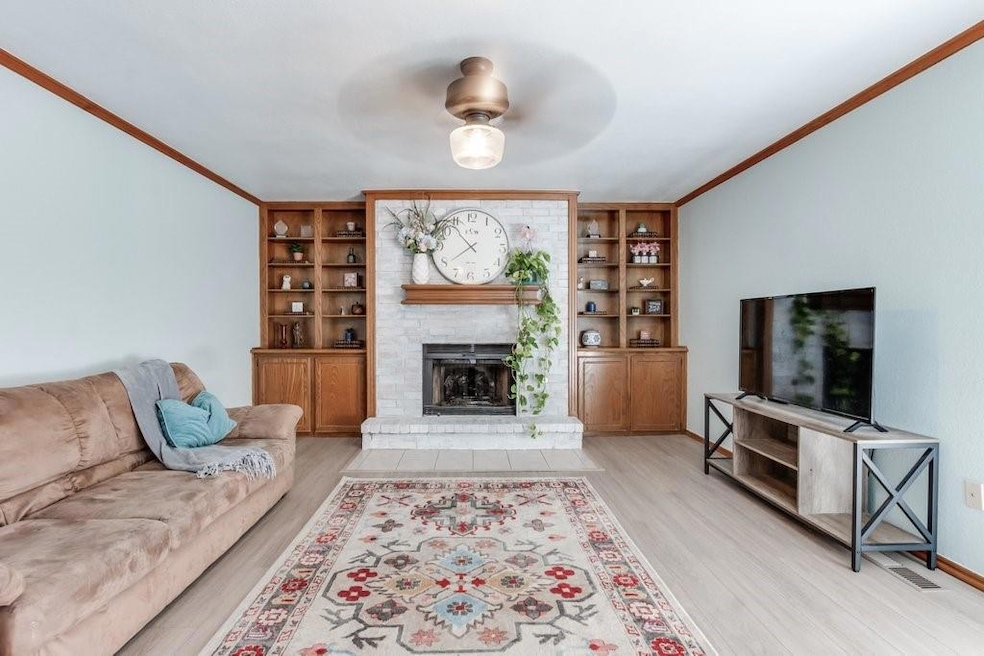 Living room with light wood-type flooring, crown m