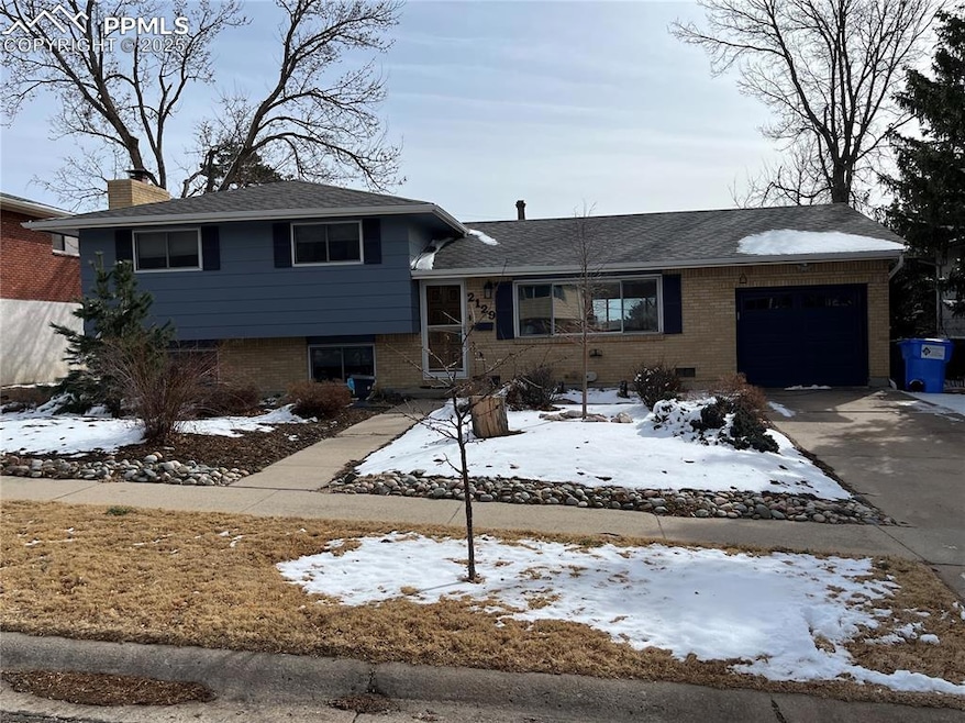 Tri-level home featuring brick siding, driveway, a