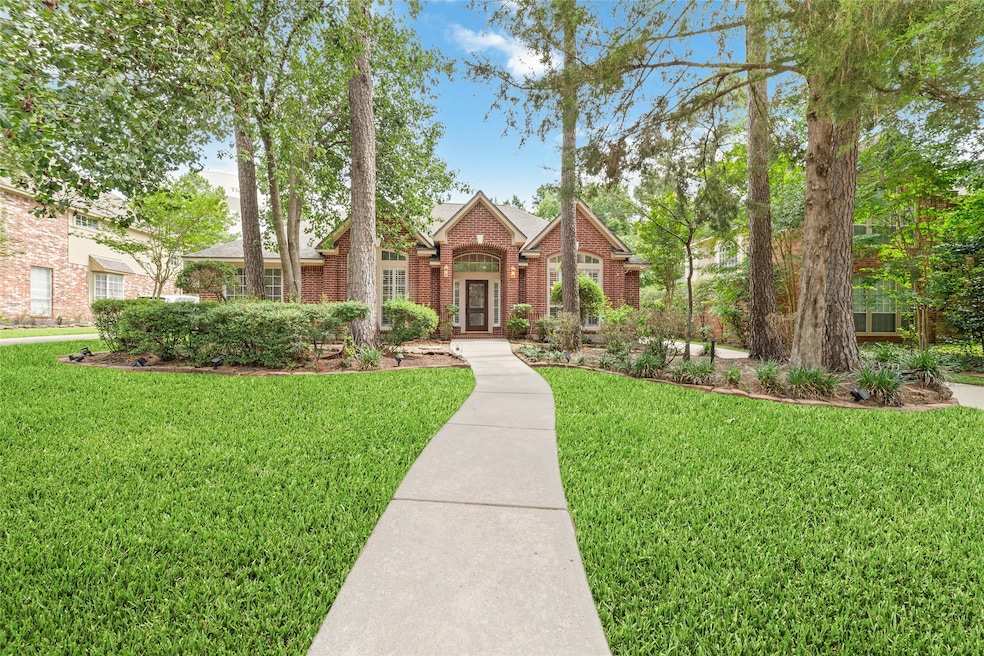 This home features a well-manicured lawn, mature t