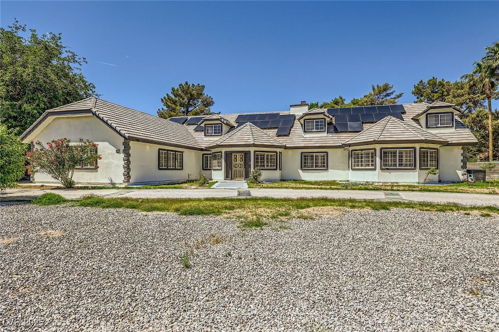 View of front of property with a chimney, solar pa