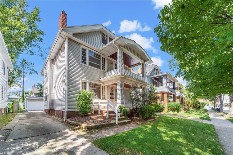 View of front of house with garage, a porch, and a front lawn