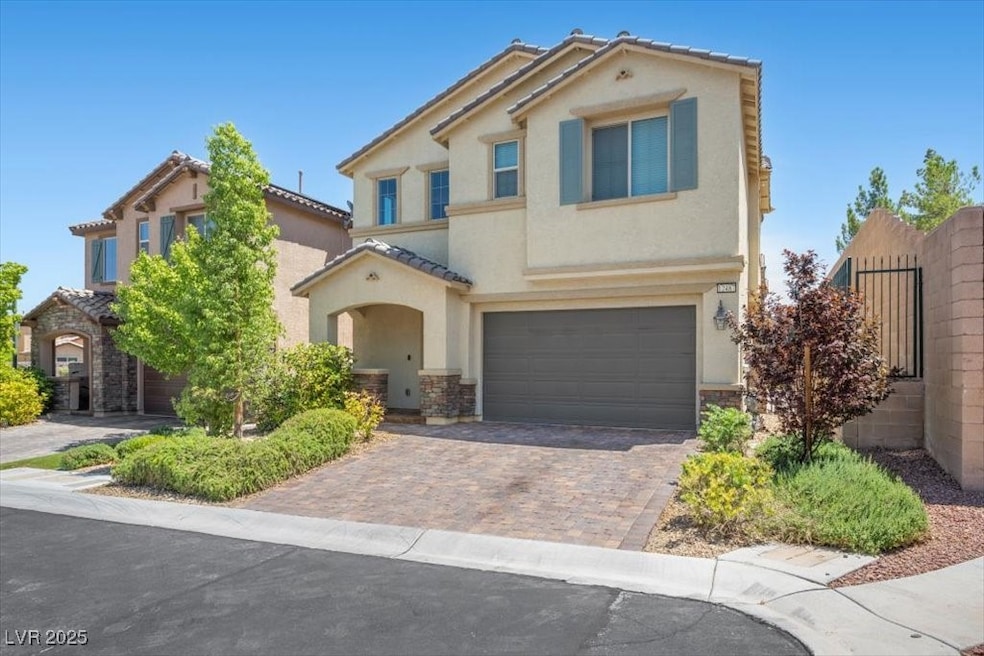 Mediterranean / spanish-style home featuring stone siding, stucco siding, decorative driveway, and an attached garage