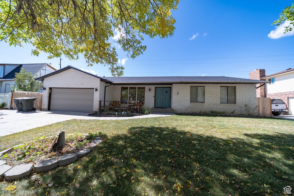 Single story home featuring driveway, an attached garage, and brick siding