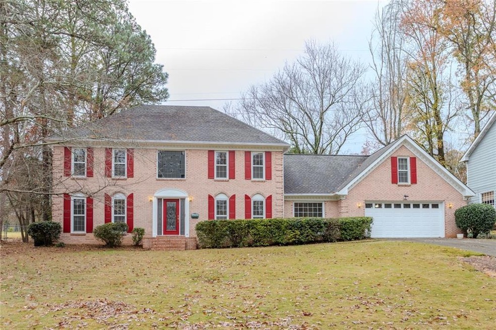 Colonial inspired home with a front yard and a gar