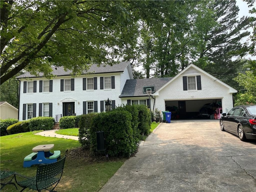 Colonial inspired home featuring a front yard, driveway, and brick siding