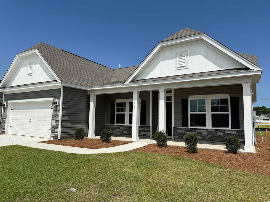 View of front of property with stone siding, a porch, roof with shingles, and a front yard