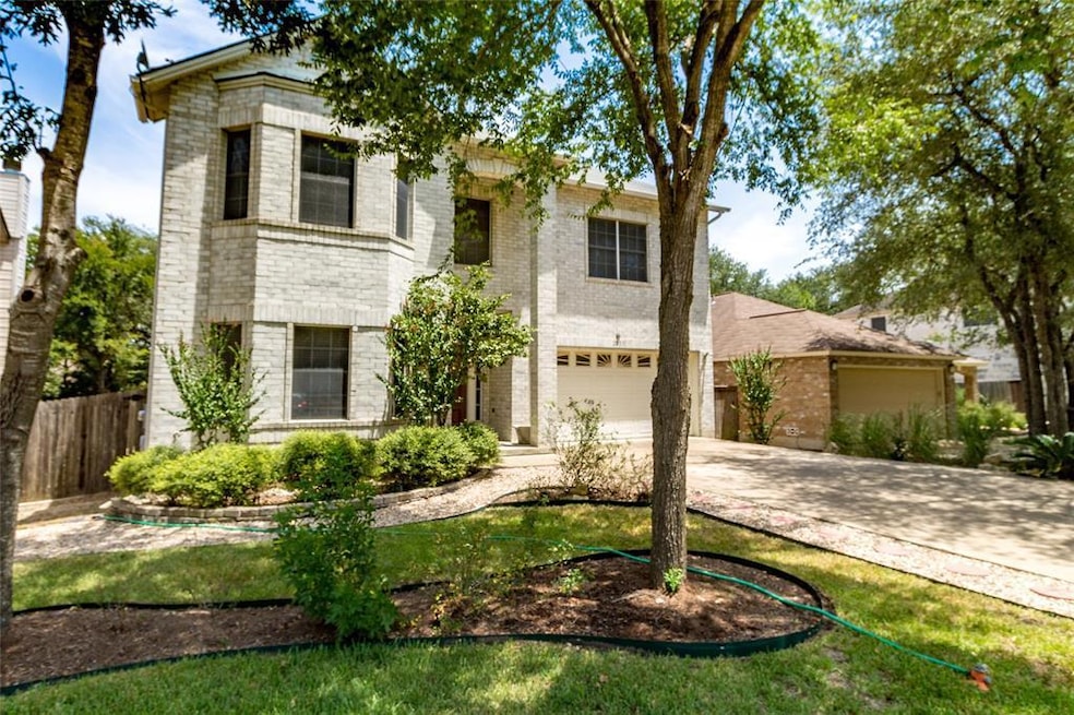 View of front facade with concrete driveway, bric