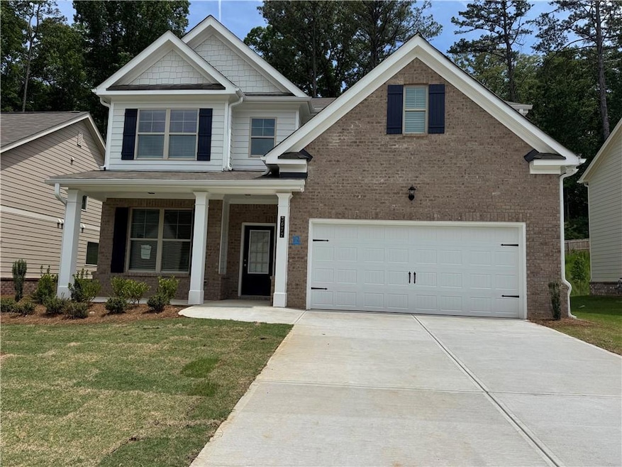 Craftsman inspired home with concrete driveway, brick siding, and a front yard
