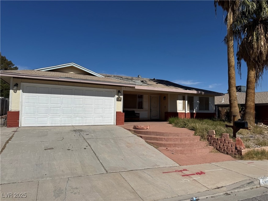 Ranch-style home with driveway, brick siding, and