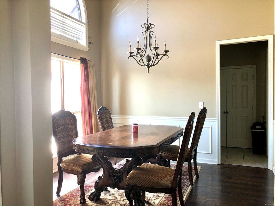 Dining Room has dramatic tall ceiling and half-moo