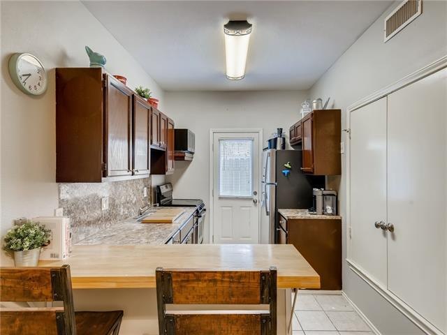 Galley kitchen with wood block bar top.