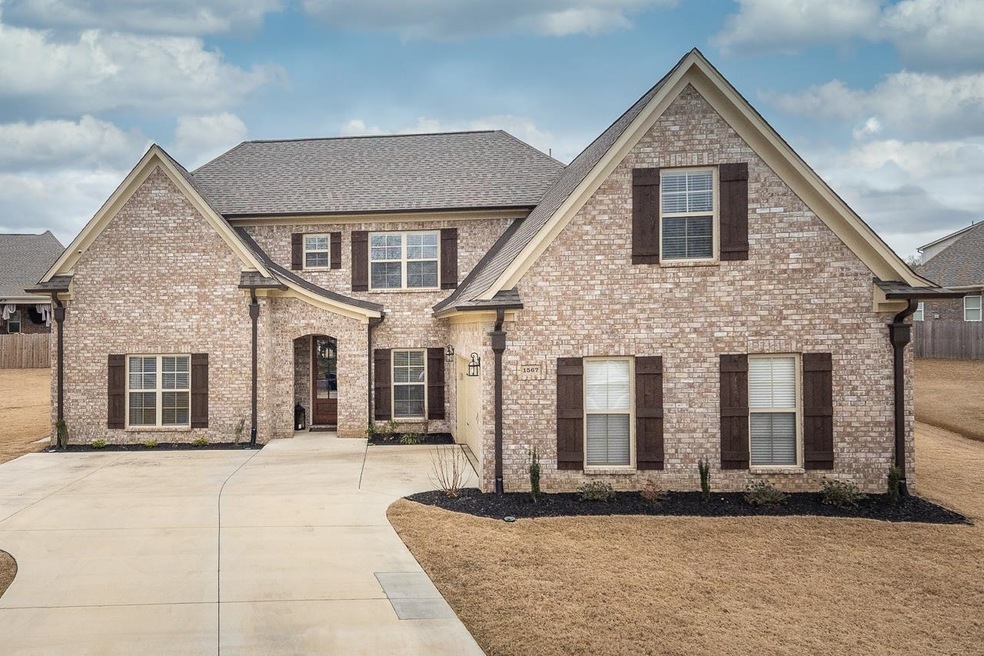 View of front of house featuring fence, brick siding, and a shingled roof