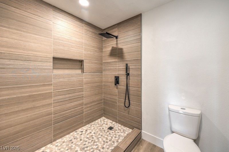 Full bathroom with a tile shower, wood finished fl