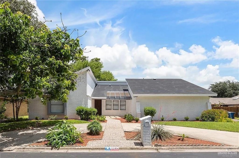 View of front of home with brick siding, roof with shingles, and concrete driveway