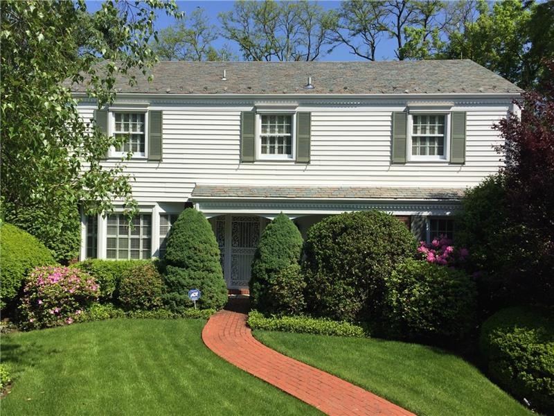 A Colonial brick walkway leads to the welcoming co