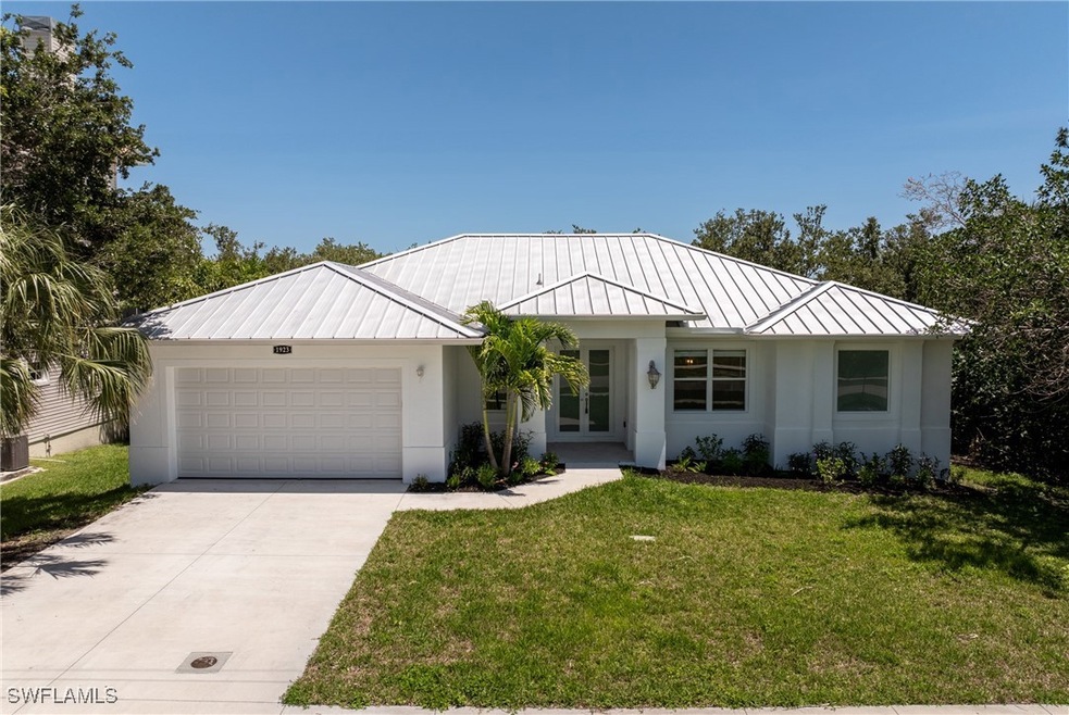 Single story home with a standing seam roof, metal roof, a garage, french doors, and driveway