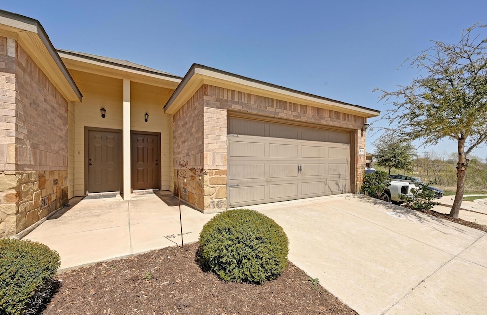 Doorway to property with a garage, stone siding, 