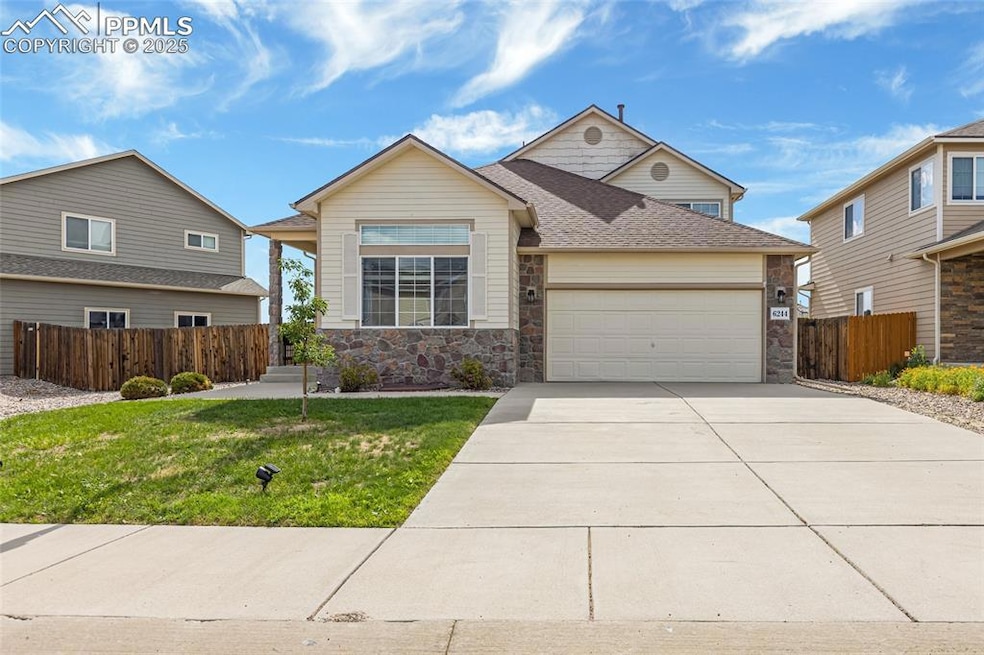 View of front of property with an attached garage, stone siding, driveway, and roof with shingles