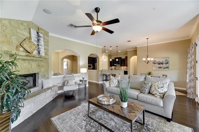 Open living with fireplace and surround sound with wood floors.