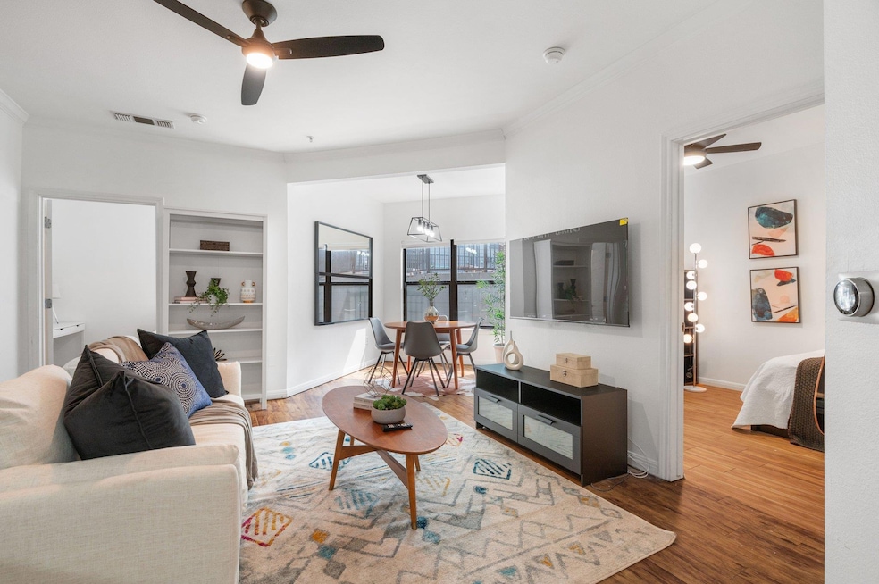 Living room featuring a ceiling fan, wood finishe