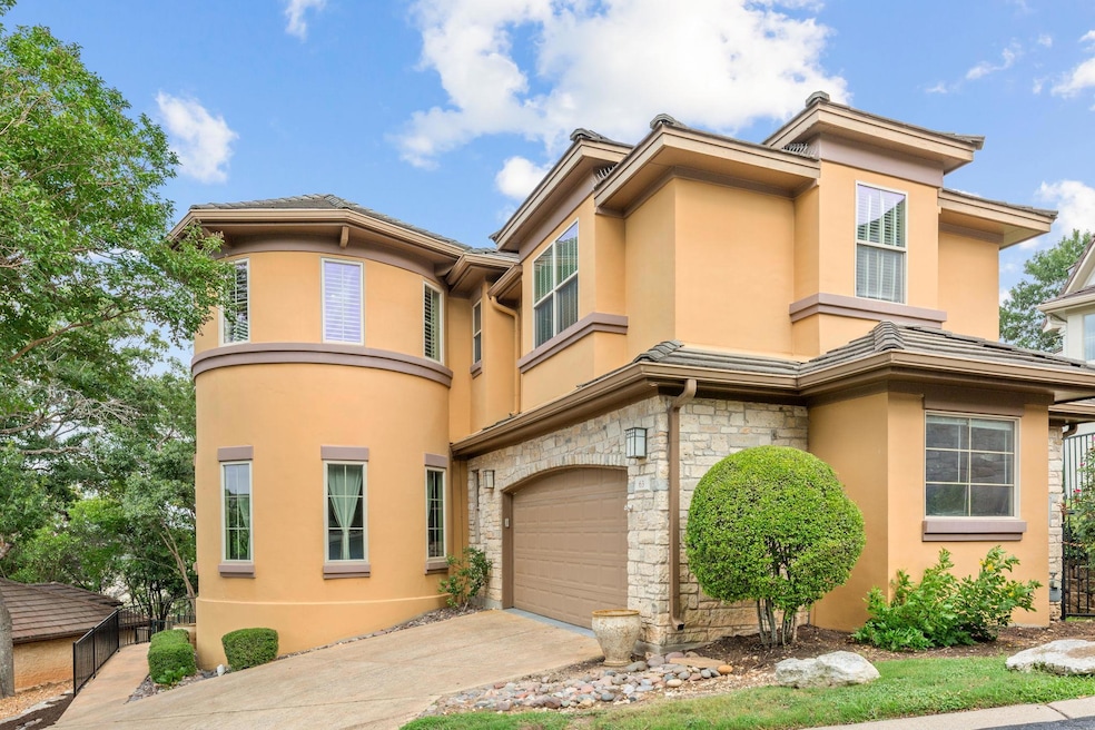 View of property featuring stucco siding, an atta
