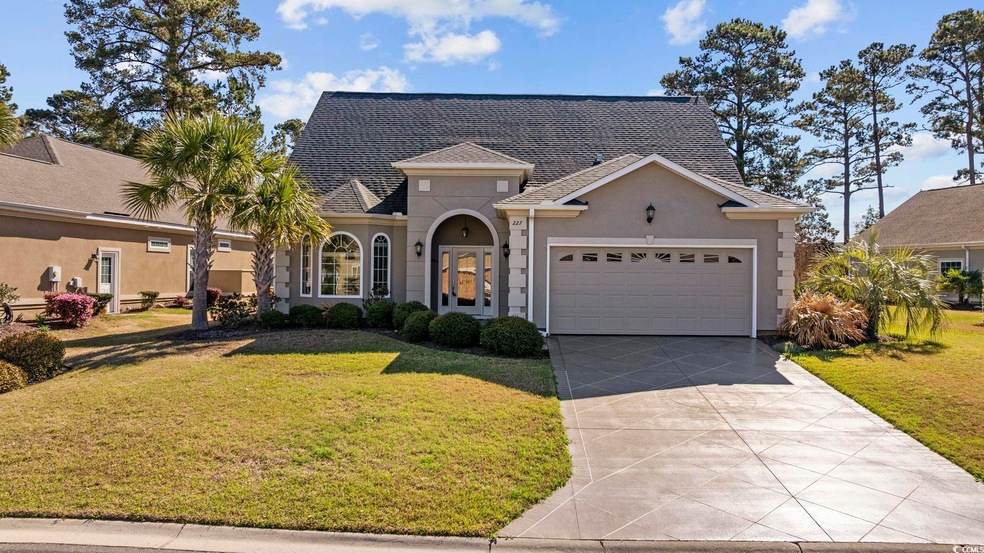 View of front of home featuring a front lawn, concrete driveway, stucco siding, and an attached garage