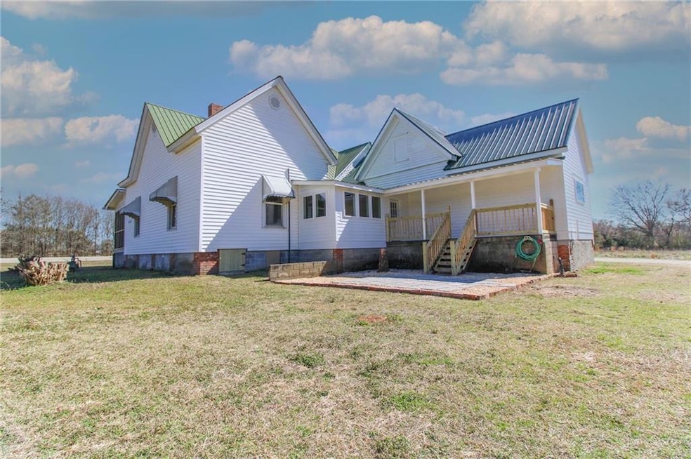 Rear view of property featuring a chimney, a lawn,