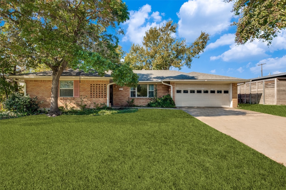Single story home with a front yard, driveway, brick siding, and a garage