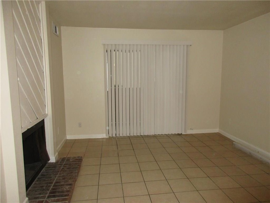 Unfurnished living room featuring a brick fireplac