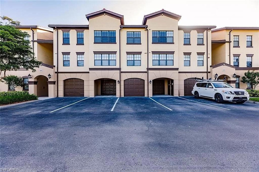 View of building exterior with an attached garage and driveway