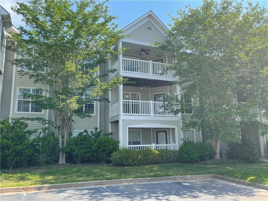 View of front of property with a front yard, a bal