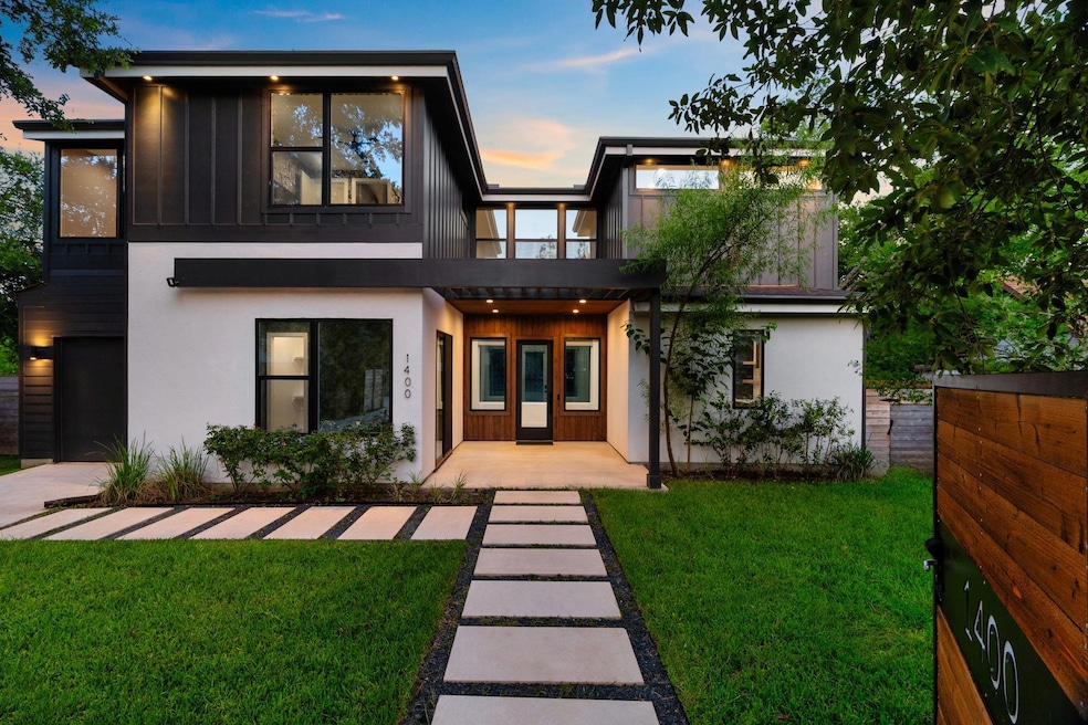 Back of house with a yard, stucco siding, a balco