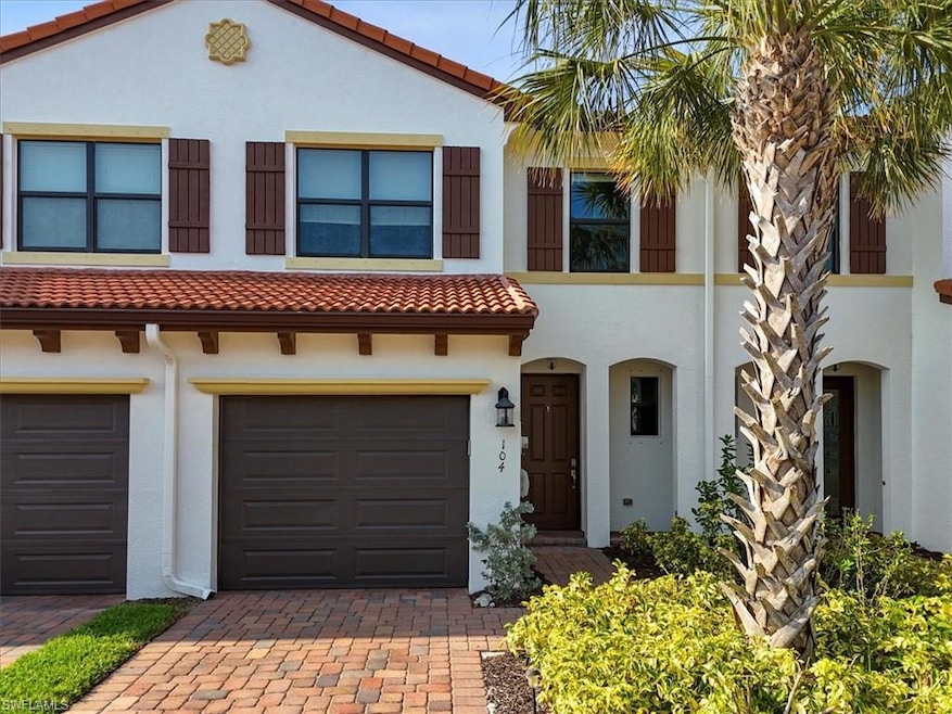 View of front of home with a tile roof, stucco siding, decorative driveway, and an attached garage