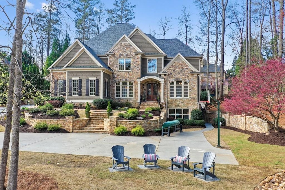 View of front of house featuring stone siding, a front yard, and a shingled roof
