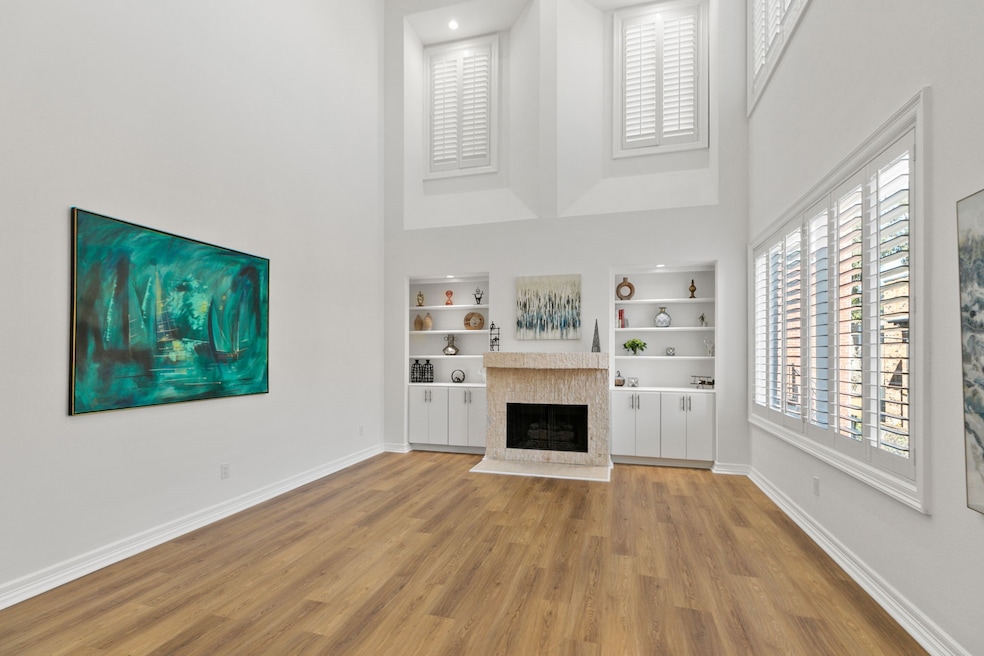 Imagine living your life in this GRAND two-story living room filled with natural light from Pella windows that have been resealed both interior and exterior. The stately fireplace has cabinets and shelves on both sides.