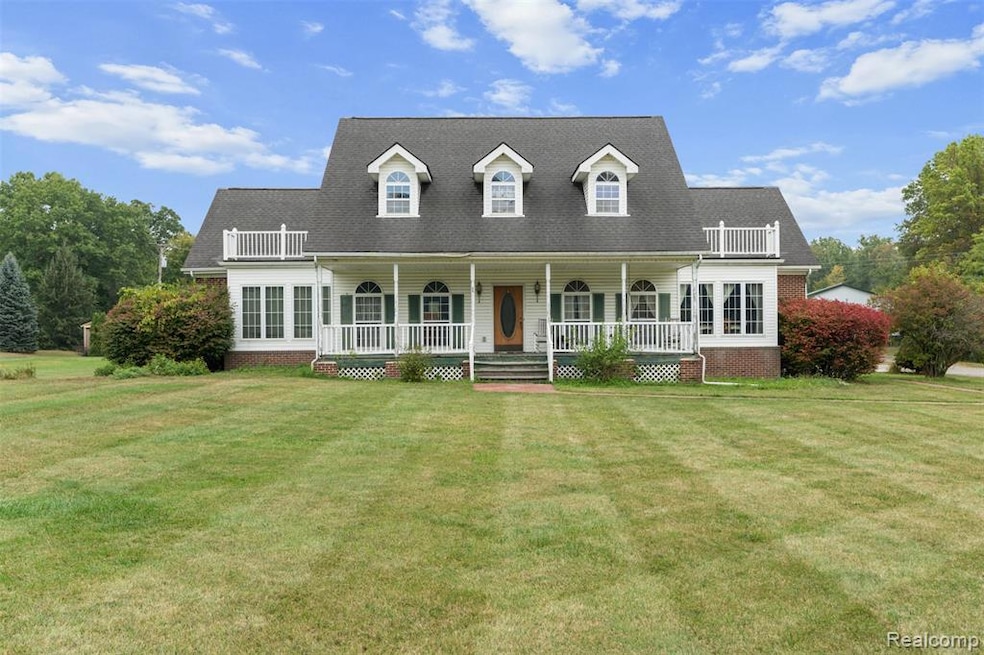New england style home with a front lawn, a porch, and roof with shingles