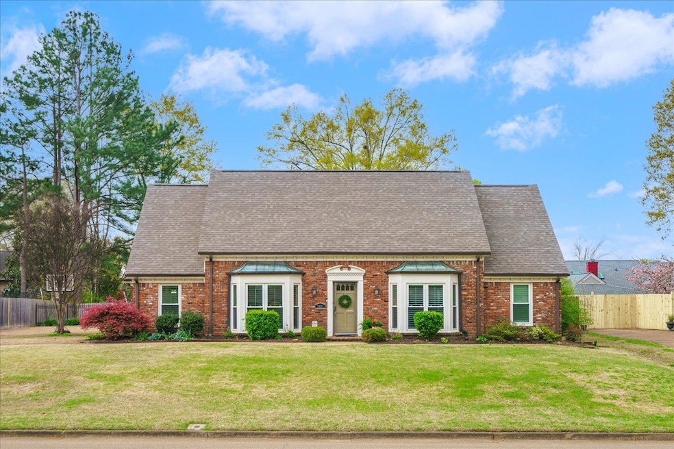 View of front facade with brick siding, fence, roo