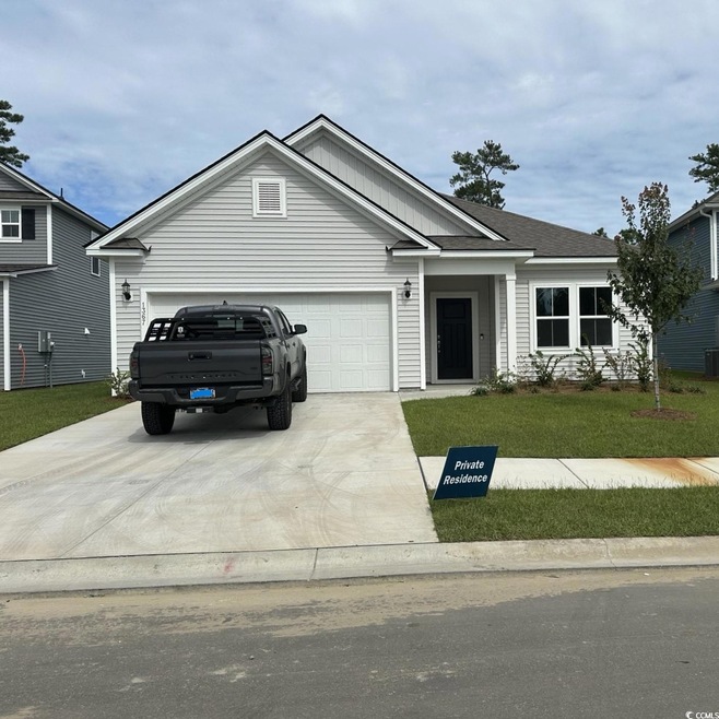 View of front facade with a garage and a front law