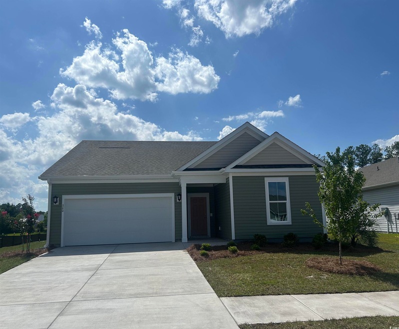Ranch-style home featuring driveway, a garage, and a front lawn