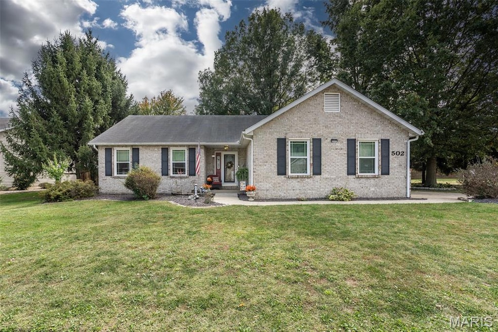 Single story home with brick siding and a front yard