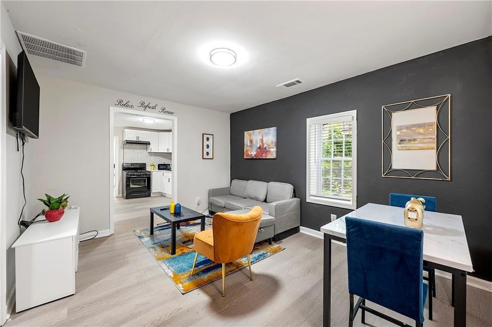 Living room featuring light wood-style flooring and baseboards