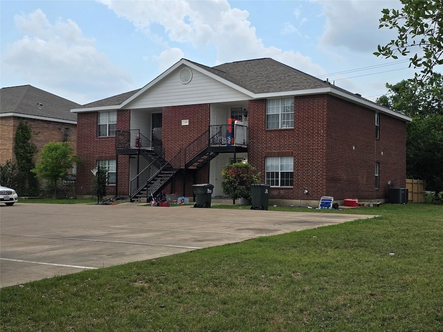 View of building exterior with stairs, central AC