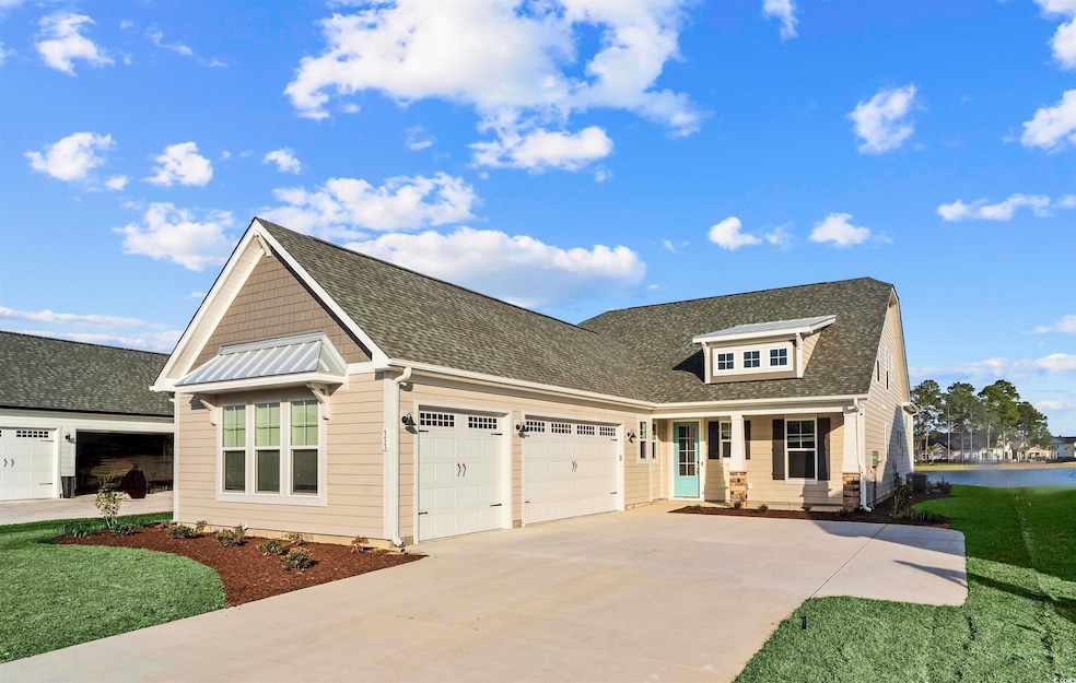 Craftsman-style home with a garage, driveway, roof with shingles, and a water view