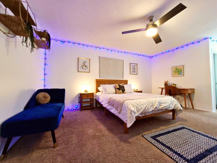 Carpeted bedroom with ceiling fan