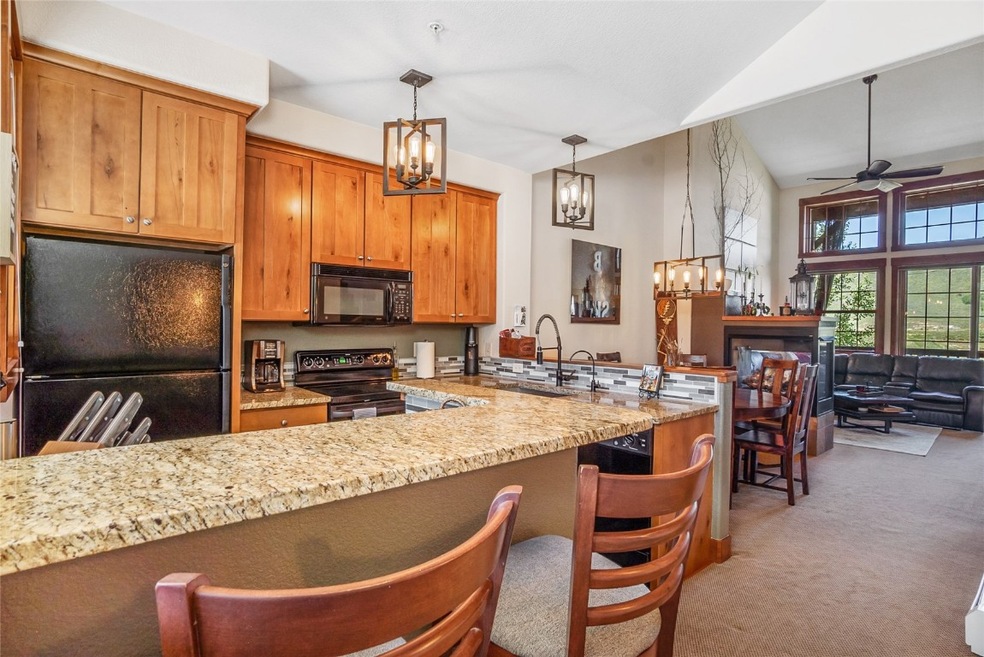Kitchen with a kitchen bar, black appliances, hang