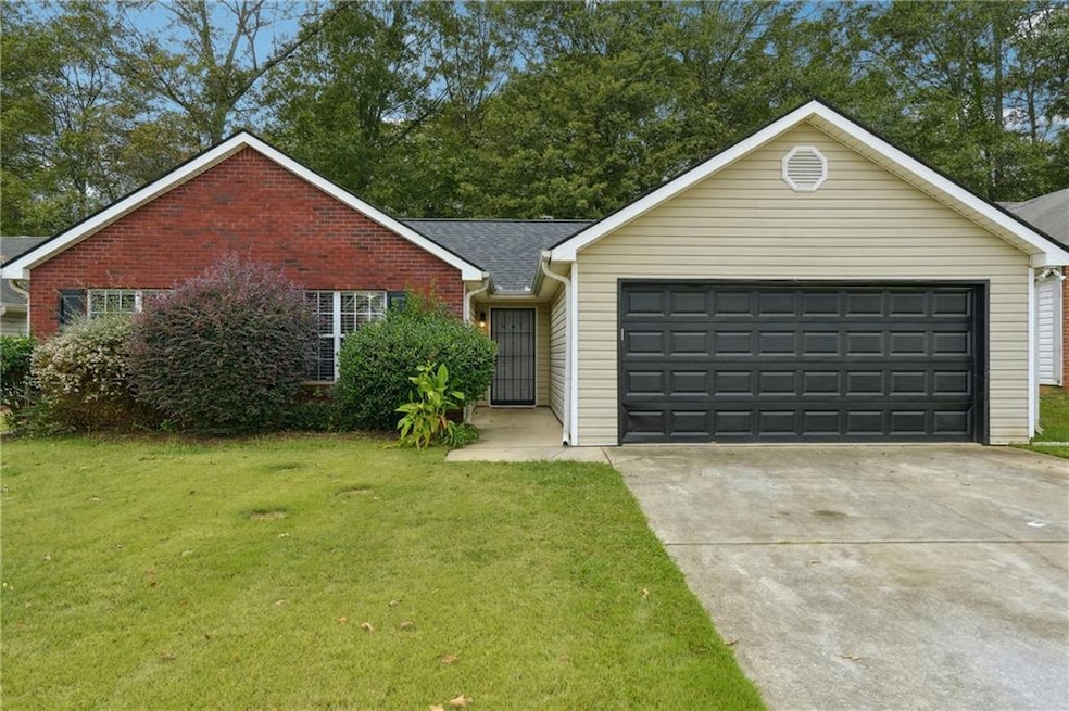 Ranch-style home with a front yard and a garage
