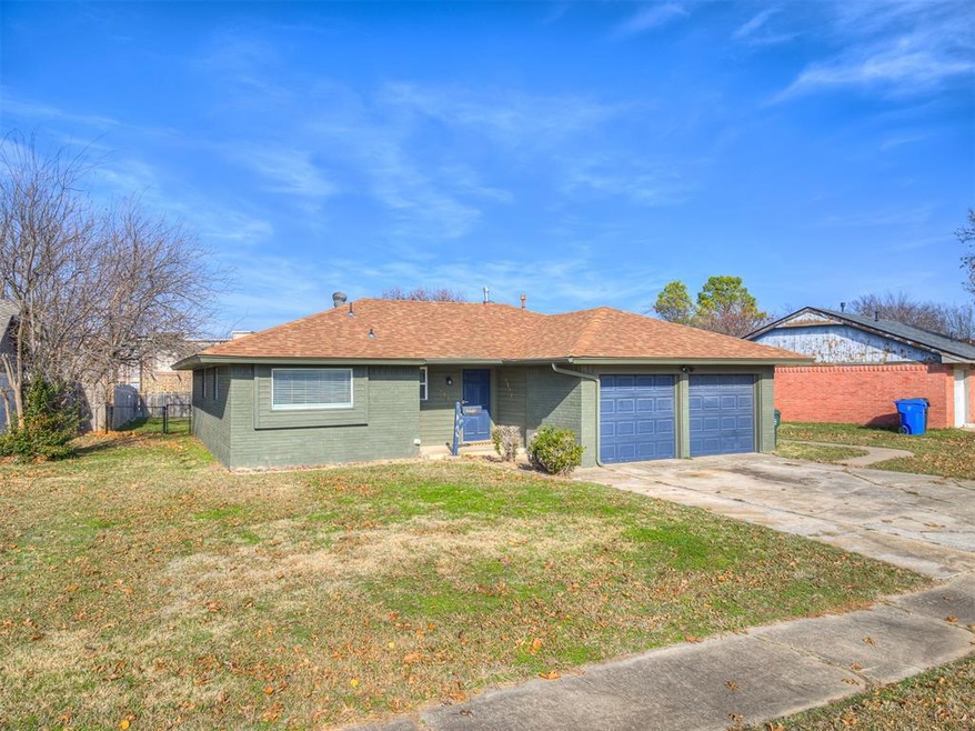 Ranch-style house with a garage and a front lawn