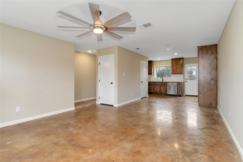 Unfurnished living room with sink, concrete floori