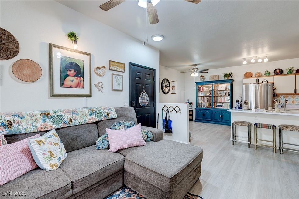 Living room with a ceiling fan and light wood-styl